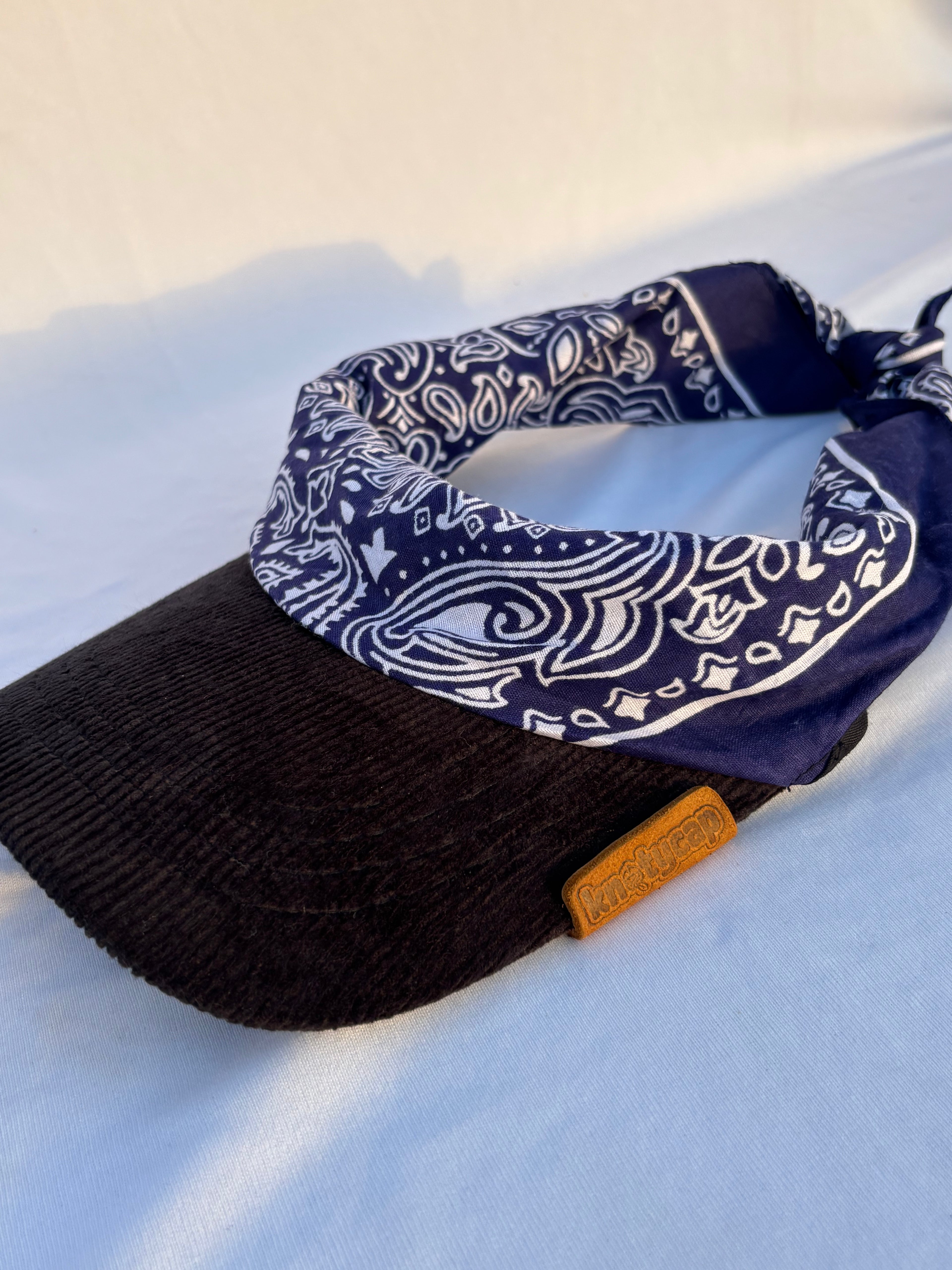  Top-down angled view of Knotycap cap and bandana hybrid in Night Run navy print